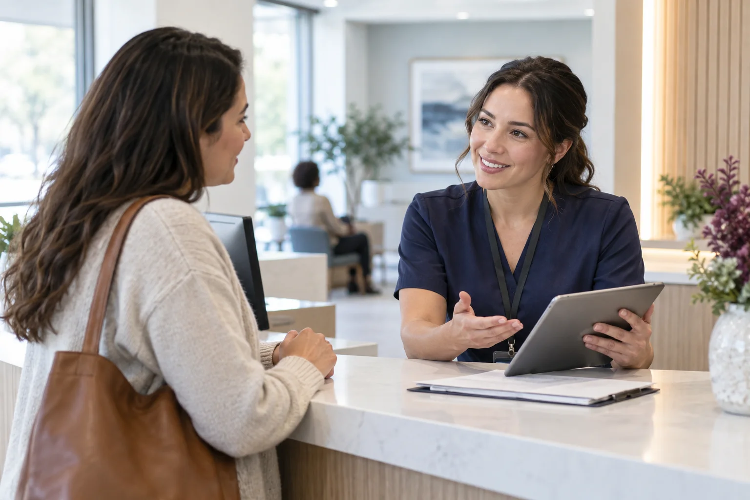 Illustrative healthcare liaison and adult visitor talking at a welcoming service desk